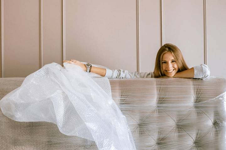 woman unwrapping new sofa