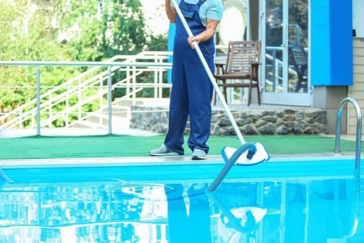 man working on cleaning the pool