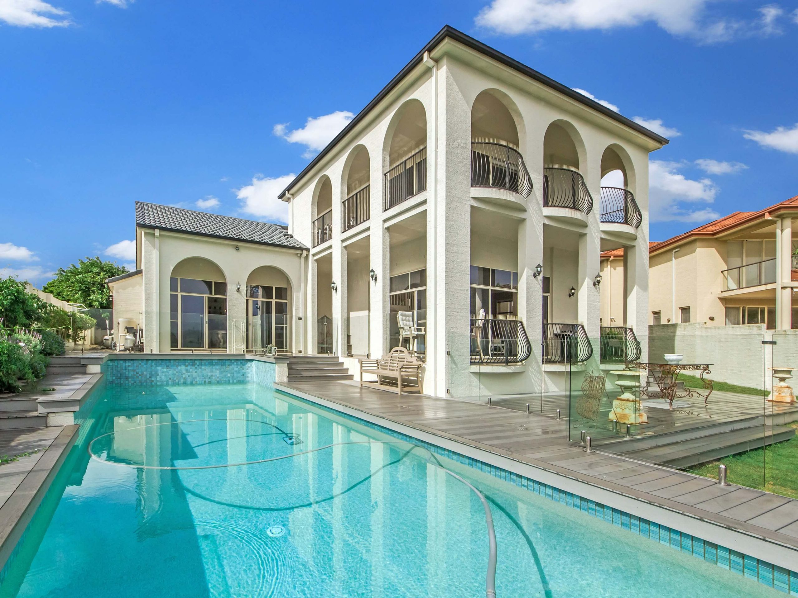 large, two-story stucco house with swimming pool