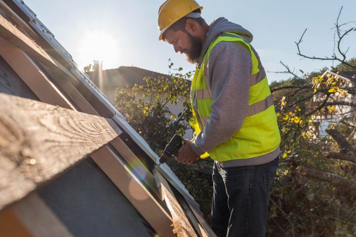 man working roof with drill