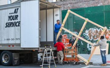 men raising window to moving truck