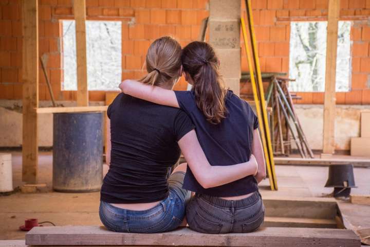 women hugging in construction of their future house