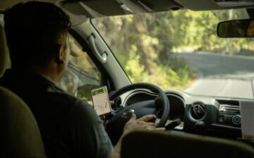 Man driving with map app on cell phone