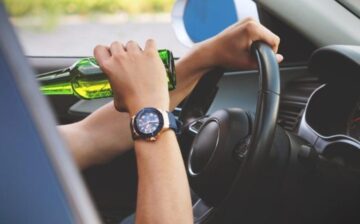 man drinking beer while driving the car