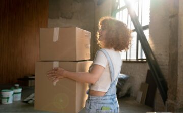 woman handling belongings cardboard boxes moving new house