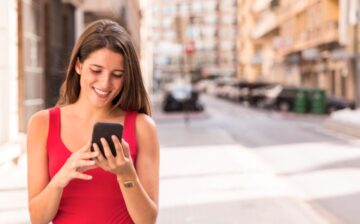 Woman with cell phone looking at apps in her new city