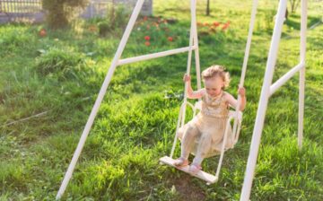 charming little girl laughs playing field