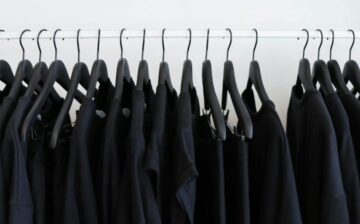 closet with black hangers and black clothes hanging