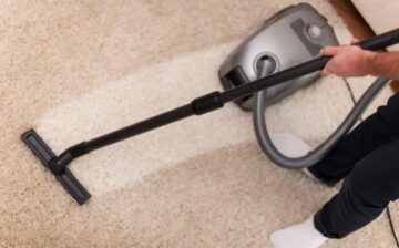 man vacuuming carpet