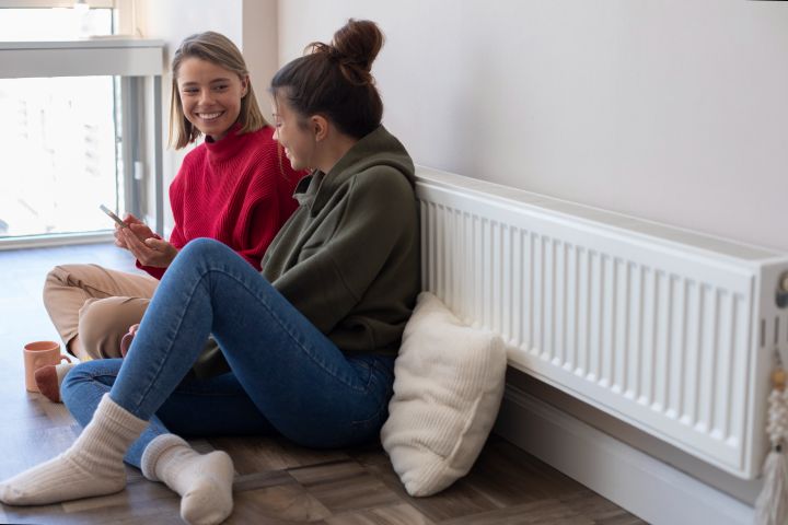 girls sitting next to the stove