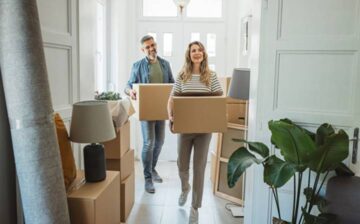 family entering house with moving boxes