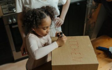 girl writing moving box