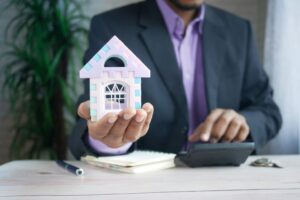 man holding plastic house