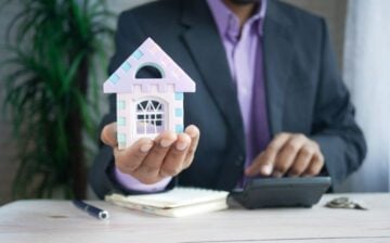 man holding plastic house