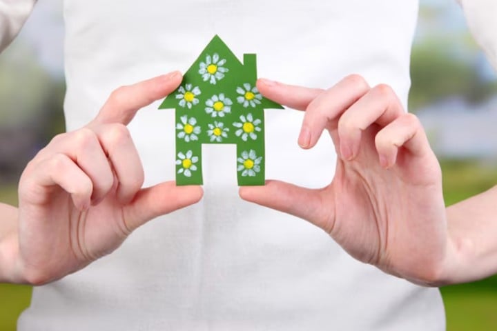 woman holding small house