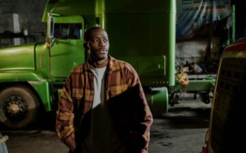 man standing near the green truck