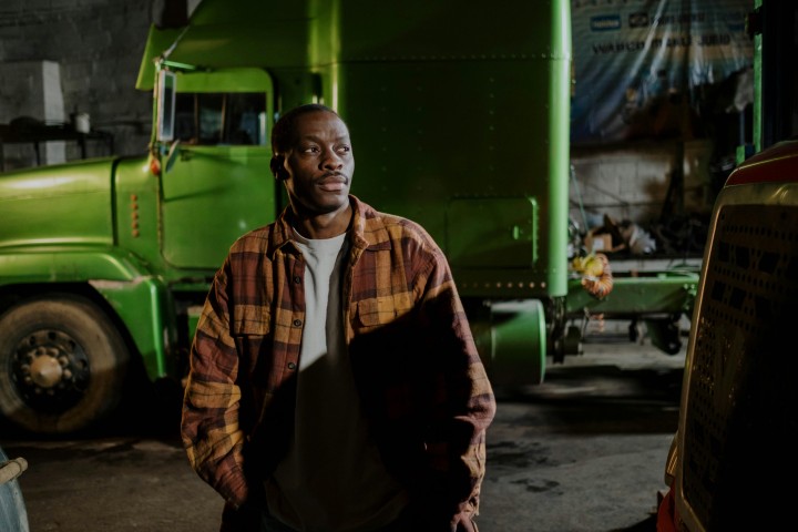 man standing near the green truck